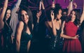 Photo of young beautiful girls dancing on party in night club wearing classy stylish dresses smiling relaxing together