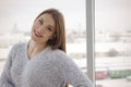 Photo of young beautiful happy smiling woman with long hair near the window. Royalty Free Stock Photo