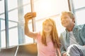 Portrait of young beautiful teenage girl taking selfie with her father in airport Royalty Free Stock Photo