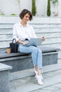 Young beautiful woman sitting outdoors using laptop computer Royalty Free Stock Photo