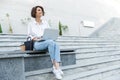 Young beautiful woman sitting outdoors using laptop computer Royalty Free Stock Photo