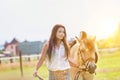 Portrait of young beautiful woman standing with horse in ranch Royalty Free Stock Photo