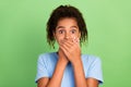 Photo of young black preteen girl cover mouth hands scared mute oops fail problem secret over green color