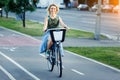 Photo of young blonde in long denim skirt sitting on bike on road in city on summer day Royalty Free Stock Photo