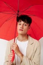 Photo young boyfriend holding an umbrella in the hands of posing fashion light background unaltered Royalty Free Stock Photo