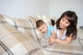 Photo of a young brunette and a 7-years boy playing with a gray kitten sitting on a sofa in a flat Royalty Free Stock Photo