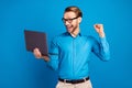 Photo of young business man happy positive smile look laptop celebrate victory lucky success isolated over blue color