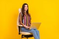 Photo of young business woman happy positive smile sit chair work laptop office isolated over yellow color background Royalty Free Stock Photo