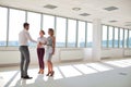 Young businessman greeting businesswoman with handshake standing by colleague in new office Royalty Free Stock Photo