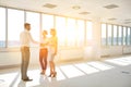 Young businessman greeting businesswoman with handshake standing by colleague in new office Royalty Free Stock Photo
