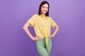 Photo of young chaming girl hands on waist confident wear casual clothes isolated over violet color background Royalty Free Stock Photo