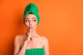 Photo of young charming lady forefinger close lips look empty space wear green towel turban isolated orange color Royalty Free Stock Photo