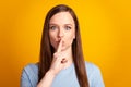 Photo of young charming woman cover lips finger shh keep secret confidential isolated over yellow color background Royalty Free Stock Photo