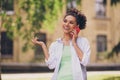 Photo of young cheerful afro woman happy positive smile speak talk conversation smartphone summer park walk