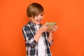 Photo of young cheerful boy race speed addicted play mobile weekend over orange color background