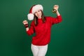 Photo of young cheerful girl happy positive smile hold hands balls decor christmas santa hat isolated over green color Royalty Free Stock Photo