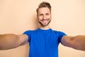Photo of young cheerful man make take selfie influencer journey isolated over beige color background