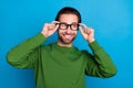 Photo of young cheerful positive handsome male look copyspace thinking wear spectacles isolated on blue color background Royalty Free Stock Photo