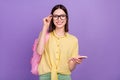 Photo of young cheerful school girl eyewear use mobile chating typing sms isolated over violet color background Royalty Free Stock Photo