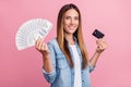 Photo of young cheerful woman hold dollars cash bank card income isolated over pink color background