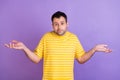 Photo of young clueless ignorant man shrug shoulders no idea puzzled isolated on purple color background Royalty Free Stock Photo