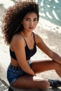 Photo of young colombian woman with curly afro hair wearing fashionable short jeans