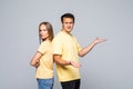 Photo of young confused loving couple gesturing with hands over grey background Royalty Free Stock Photo