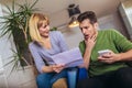 Young couple embracing and calculating the bills at home Royalty Free Stock Photo
