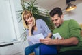 Young couple embracing and calculating the bills at home Royalty Free Stock Photo