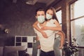 Photo of young couple lady guy spend quarantine isolation together stay home hugging piggyback happy emotions have fun