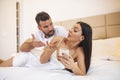 Photo of young couplein bed, woman use smartphone try explain envy angry husband she dont have another man point hand screen feel Royalty Free Stock Photo