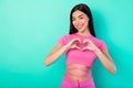 Photo of young cute girl in trendy crop top showing heart symbol express her love to boyfriend isolated on turquoise