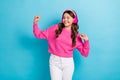 Photo of young dancing satisfied teenager schoolgirl wear new wireless pink headphones hands up active dance isolated on