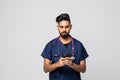 Photo of young doctor using his smartphone white background Royalty Free Stock Photo