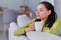 Photo of young dreamy afro american peaceful woman look hold hand mug indoors inside house home flat Royalty Free Stock Photo