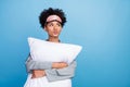 Photo of young dreamy black girl embrace pillow interested look empty space bed isolated over blue color background Royalty Free Stock Photo