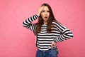 Photo of young european amazed, shocked, surprised beautiful brunette woman with sincere emotions wearing casual striped Royalty Free Stock Photo