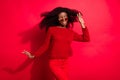 Photo of young excited afro girl happy positive smile look empty space wind blow isolated over red color background