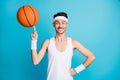 Photo of young excited cheerful sportive man happy smile spin ball on finger isolated over blue color background