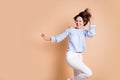 Photo of young excited crazy girl happy positive smile have fun enjoy party dance isolated over beige color background Royalty Free Stock Photo