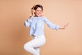 Photo of young excited crazy girl have fun enjoy music headphones dance isolated over beige color background Royalty Free Stock Photo