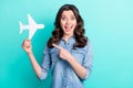 Photo of young excited girl happy positive smile point finger plane vacation flight ads advice isolated over teal color