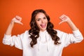 Photo of young excited girl indicate thumb herself choice cool proud winner isolated over orange color background