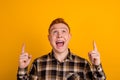 Photo of young excited man hand look point fingers empty space follow advertise isolated over yellow color background