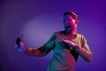 Photo of young excited man happy positive smile have fun enjoy music clubber millenial isolated over neon color Royalty Free Stock Photo