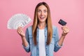 Photo of young excited woman hold cash credit card investment profit isolated over pink color background