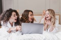 Photo of young excited women 20s wearing white housecoat lying i