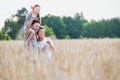 Young family walking through a field of corn on a summers day the father is carrying his younger daughter on his shoulders Royalty Free Stock Photo
