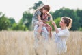 Young family walking through a field of corn on a summers day the father is carrying his younger daughter on his shoulders Royalty Free Stock Photo