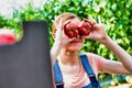 Young farmer playing with tomatoes in greenhouse